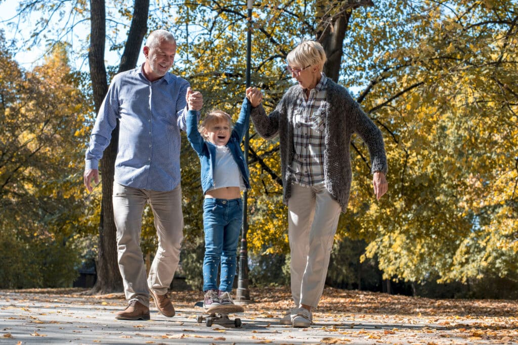 Elderly couple helping child skate